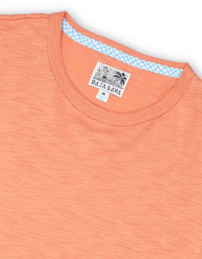 Neck label close-up of burnt salmon Solid Slub Pima tee with Baja Llama tag and blue check neck tape