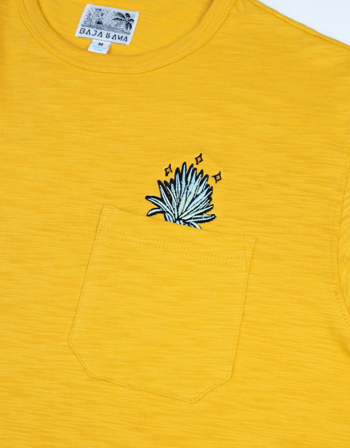 Close-up of the Baja Llama El Sativo Agave Slub Pima Pocket Tee showing the embroidered agave logo on the chest pocket.