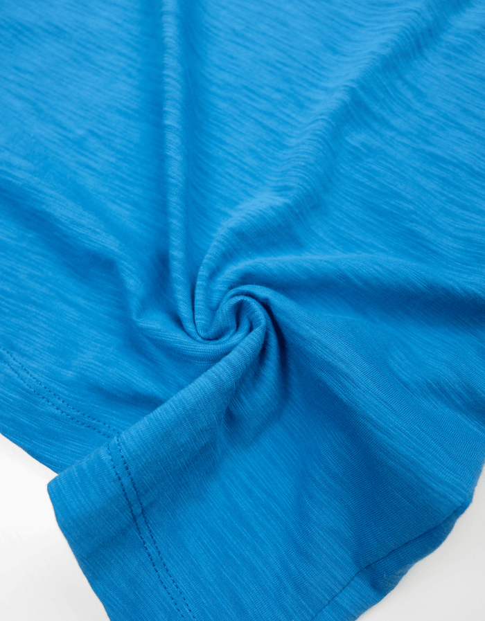 Close-up fabric texture detail of the Baja Llama Solid Blue Slub Pima Tee, highlighting the premium, soft feel of the blue slub pima cotton.