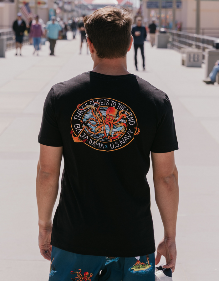 Man wearing the Baja Llama Sailor Stories Octopus black graphic tee, showcasing the 'Three Sheets to the Wind' nautical octopus design on the back.