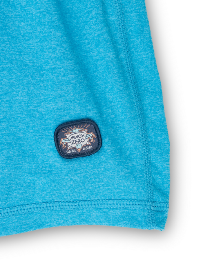Close-up detail of the Baja Llama Mach Zero Lounge Shorts in Adriatic Blue, highlighting the signature brand patch on the hem.