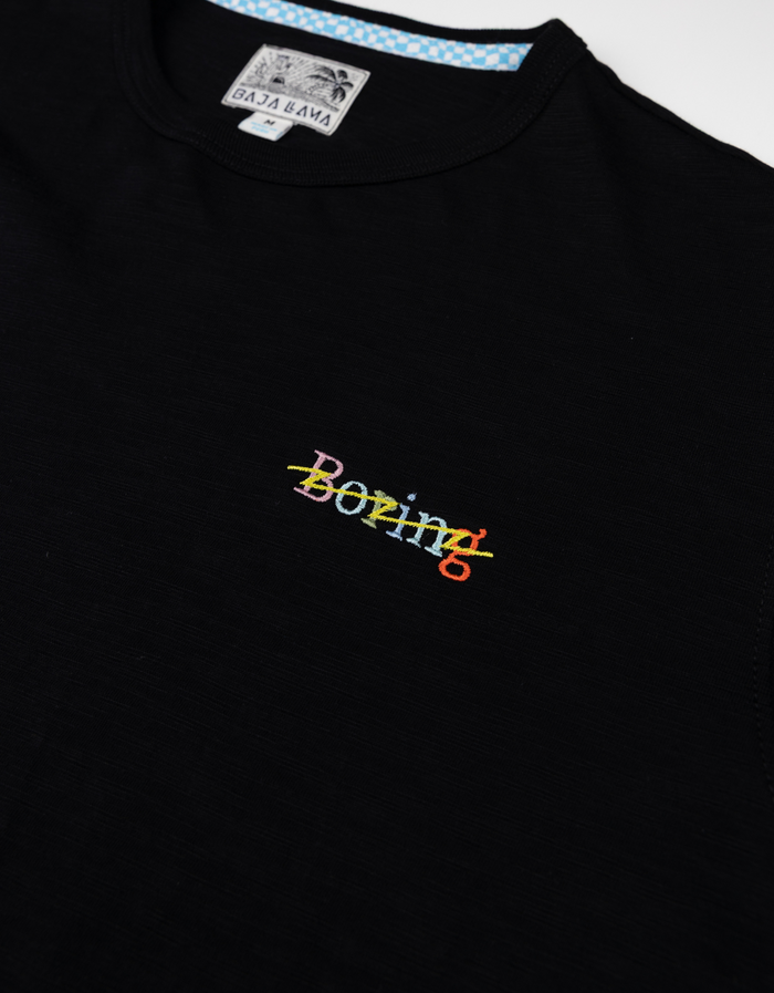 Close-up of the Baja Llama black slub pima cotton t-shirt featuring colorful "Boring" embroidery.