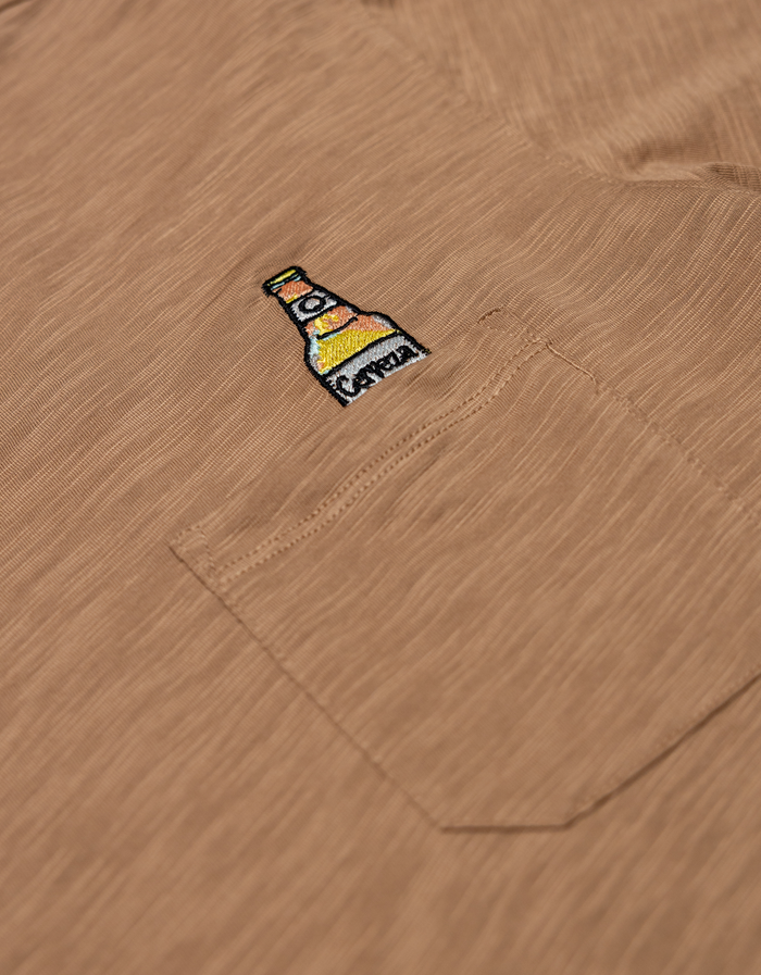 close up shot of the the beer embroidery logo on the shirt pocket.
