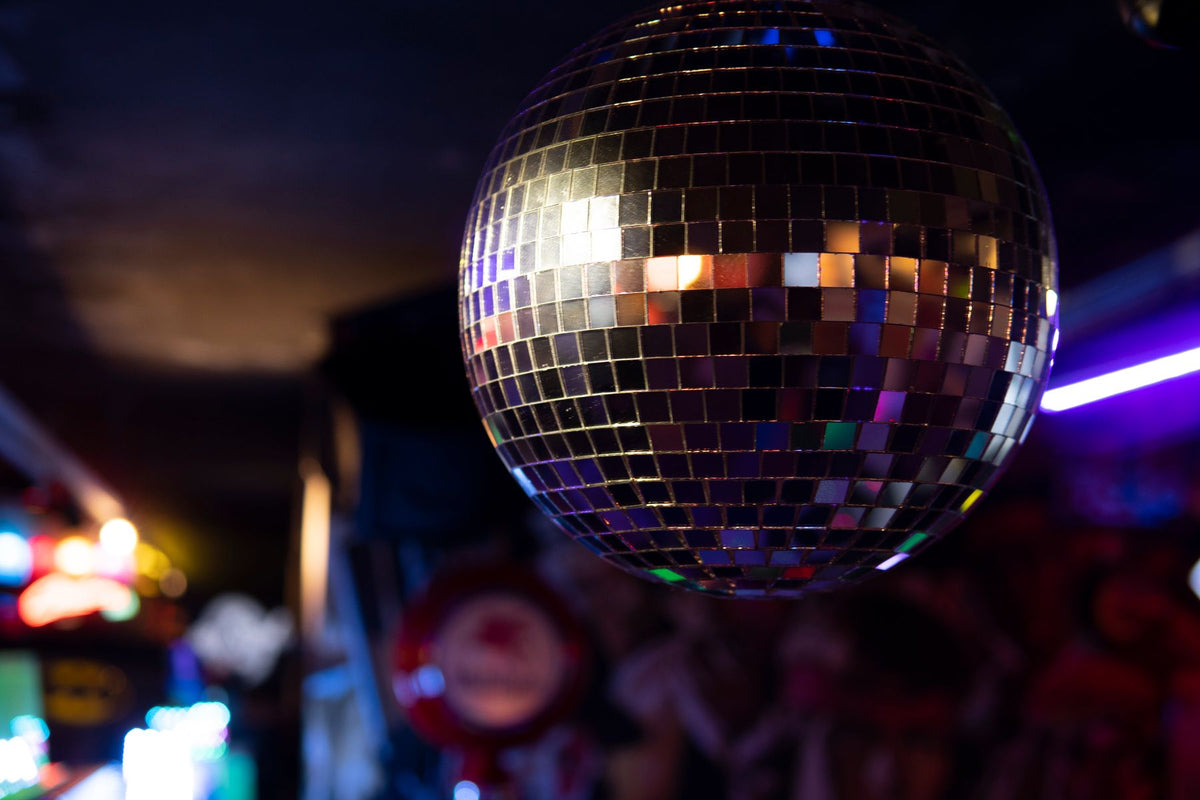 Glittering disco ball in a nightclub — setting the scene for a men's 70s party outfit.