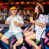 Man wearing the Baja Llama Colorful Cactus Cream Nighthawk™ Relaxed Fit Button Up shirt sitting at a bar with a friend
