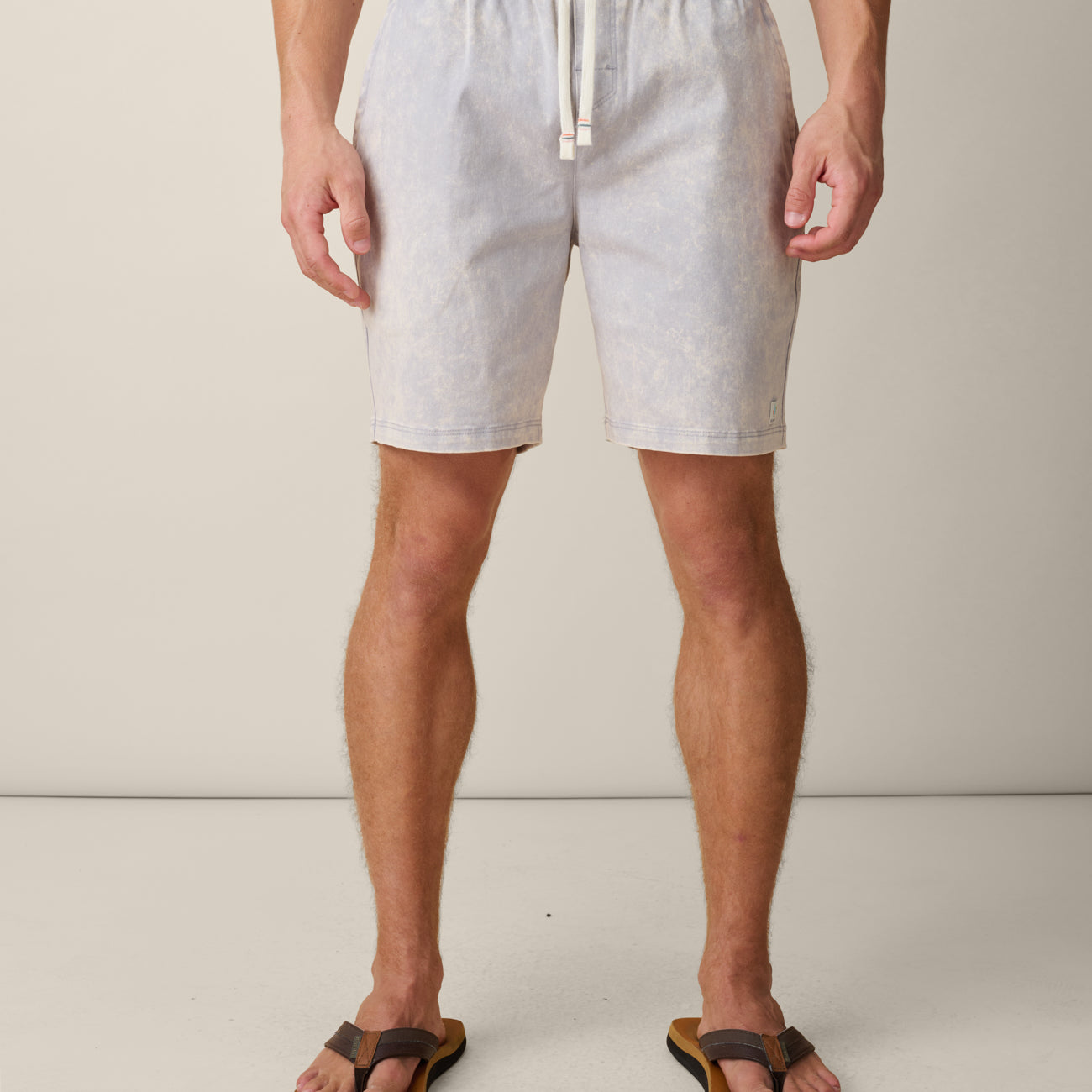 Person wearing acid wash cotton gray shorts with a drawstring on a plain background