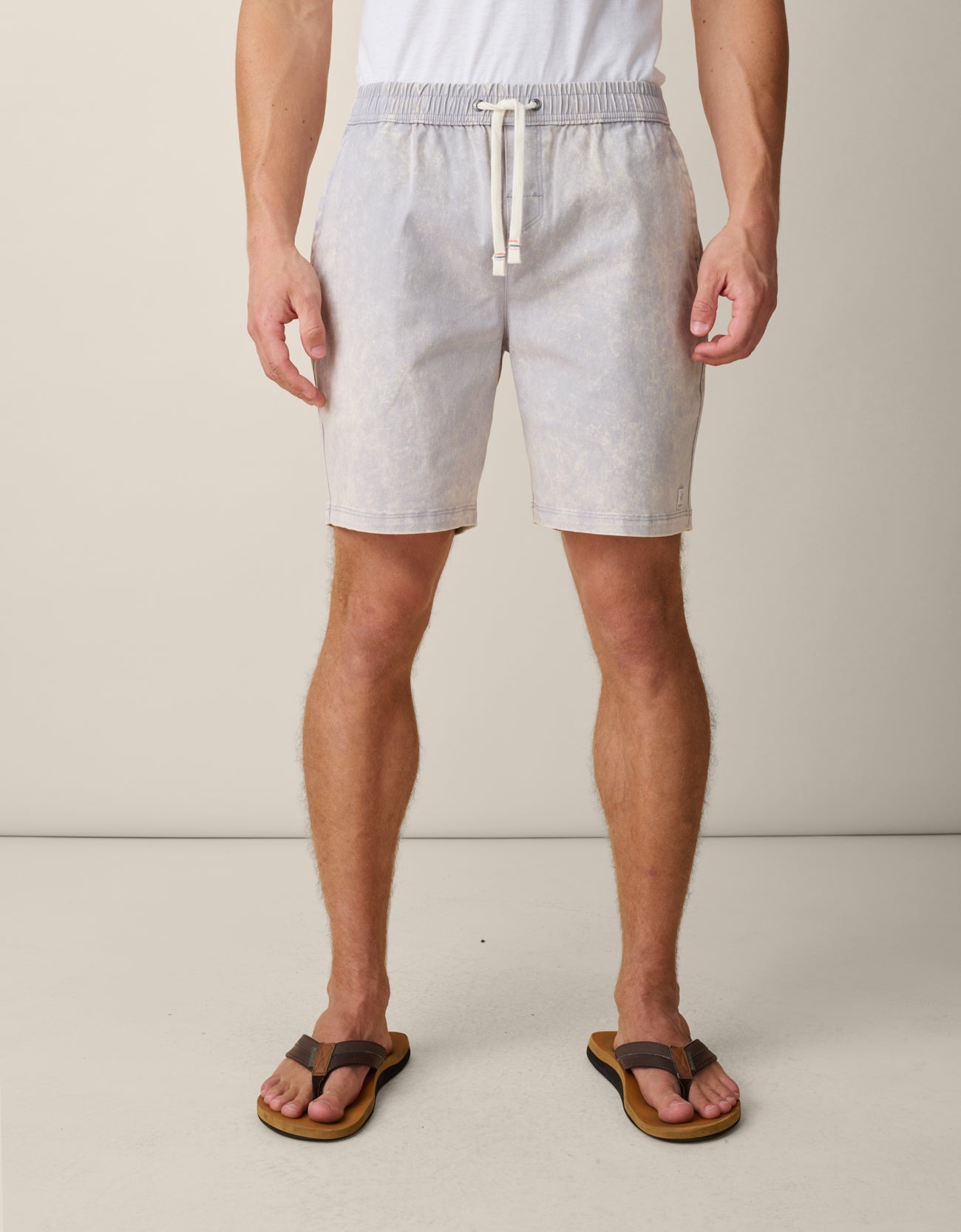 Person wearing acid wash cotton gray shorts with a drawstring on a plain background