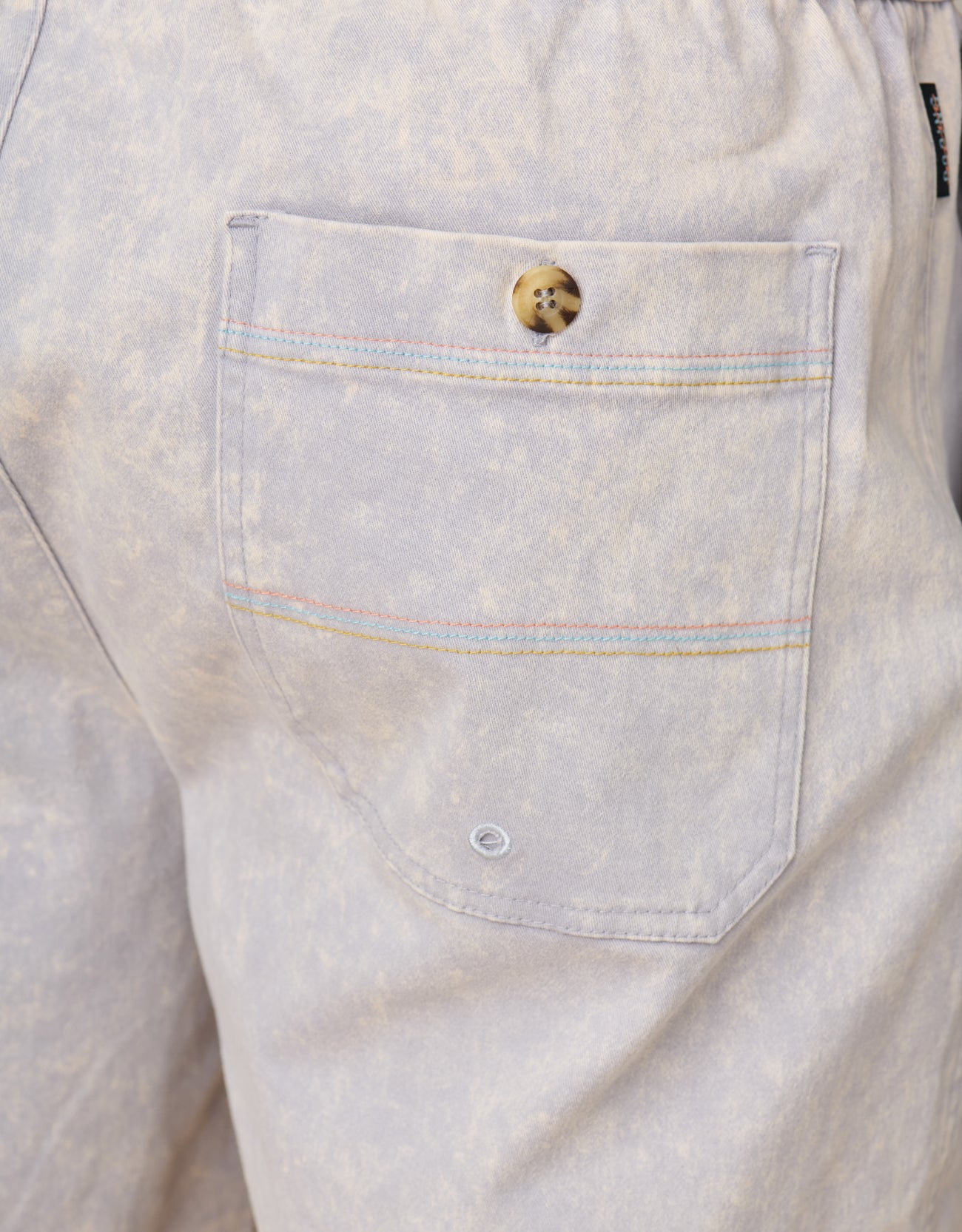 Close-up of acid wash gray shrots with a pocket and button detail.