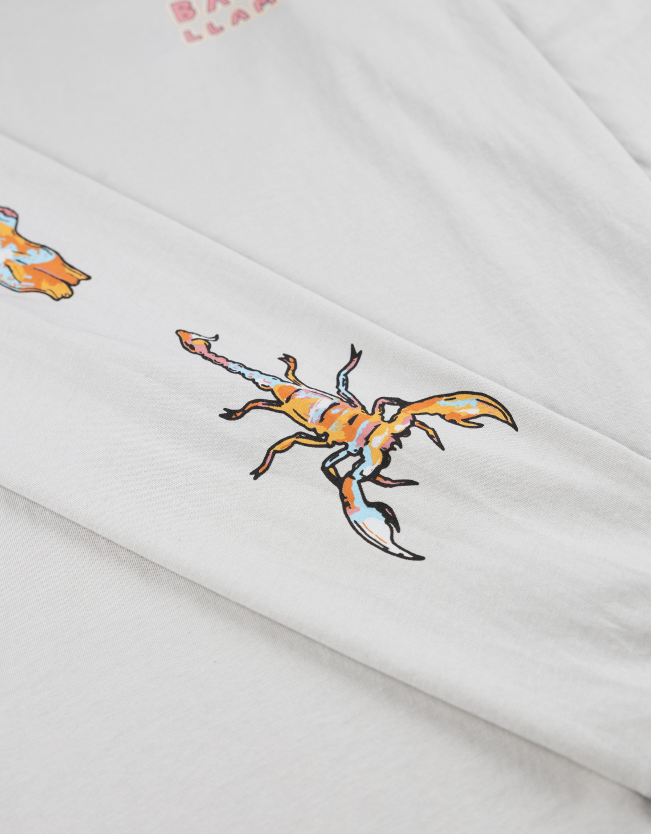 Baja Llama light desert-themed long sleeve tee with snake and Joshua tree back graphic. Soft cotton with printed sleeve details.