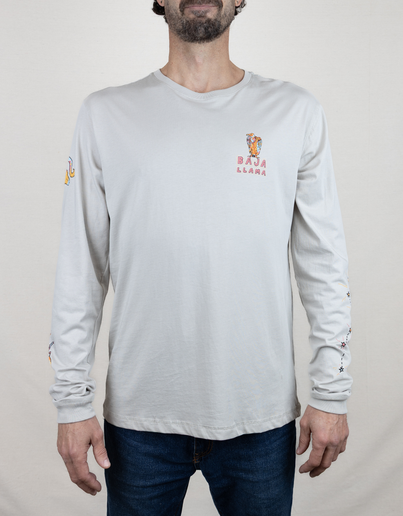 Baja Llama light desert-themed long sleeve tee with snake and Joshua tree back graphic. Soft cotton with printed sleeve details.
