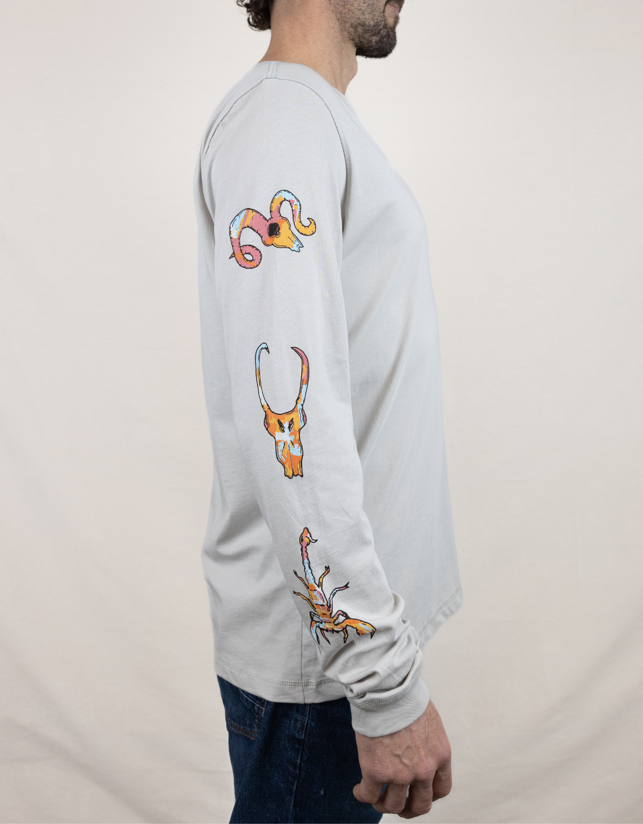 Baja Llama light desert-themed long sleeve tee with snake and Joshua tree back graphic. Soft cotton with printed sleeve details.