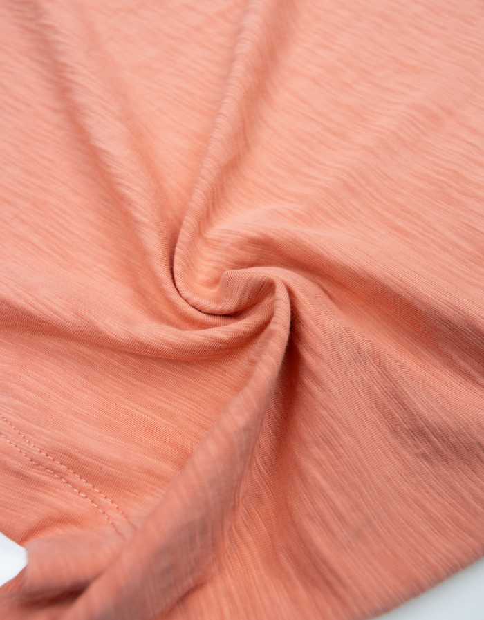 Fabric swirl close-up of burnt salmon Solid Slub Pima tee showing slub knit texture
