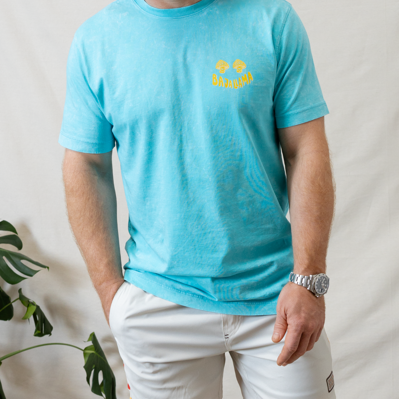 Lose Your Mind graphic tee by Baja Llama. This light turquoise colored tee features a bold, psychedelic-inspired design with vibrant colors and Lose Your Mind, Not Your Head graphic on the back. Soft fabric and a relaxed fit make it perfect for casual, adventurous style.