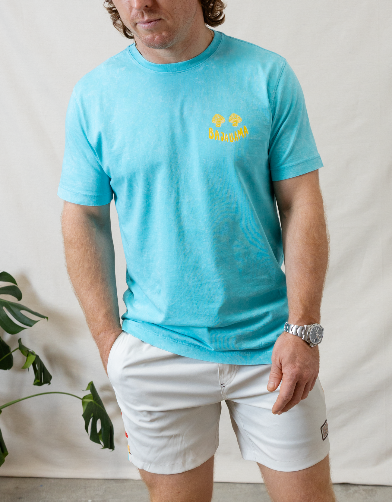 Lose Your Mind graphic tee by Baja Llama. This light turquoise colored tee features a bold, psychedelic-inspired design with vibrant colors and Lose Your Mind, Not Your Head graphic on the back. Soft fabric and a relaxed fit make it perfect for casual, adventurous style.