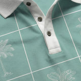 An extreme close-up of the Baja Llama La Republica Piscina Palm Green Swingers Performance Polo, detailing the textured white collar, a three-button placket with dark buttons, and the white grid with sketched palm trees.