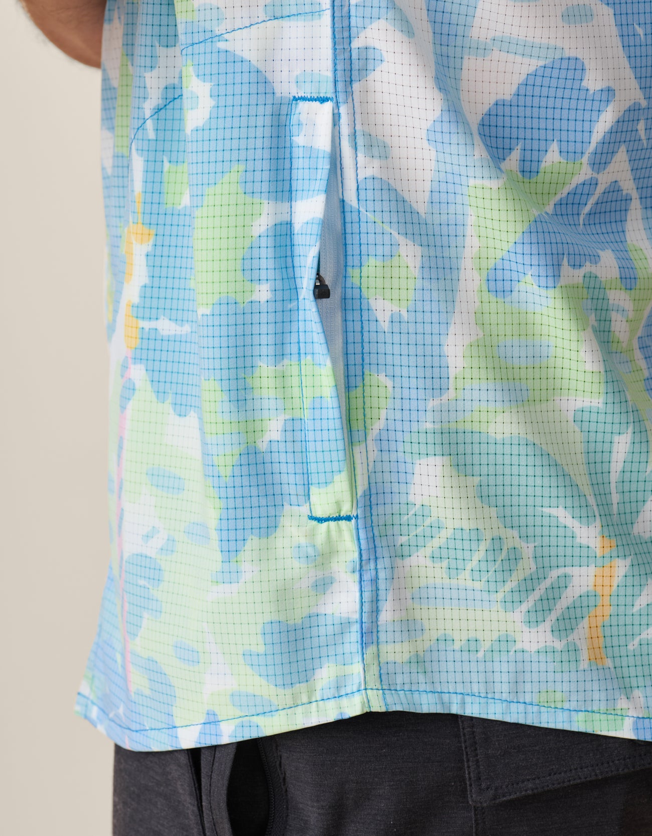 Detailed view of pastel palm print on perforated stretch fabric

