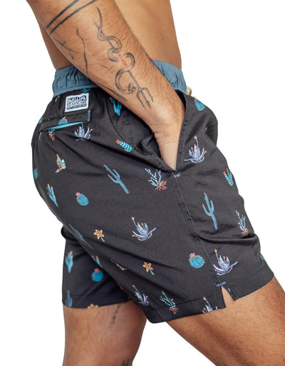Black men's swim trunks featuring different cactus prints in blue and orange highlights.
