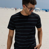 Man wearing the Baja Llama Black Onassis Jacquard Tee on a sunny beach