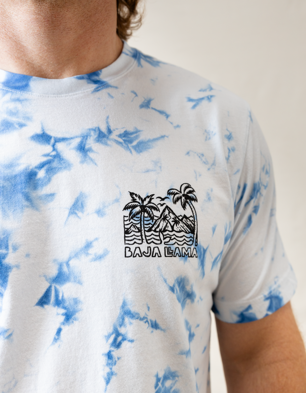 Wavy Dayz blue tie-dye graphic tee by Baja Llama. Features a vibrant, swirling tie-dye pattern with tropical ocean graphic on the front. Soft, comfortable fabric and relaxed fit, perfect for casual, adventurous style.