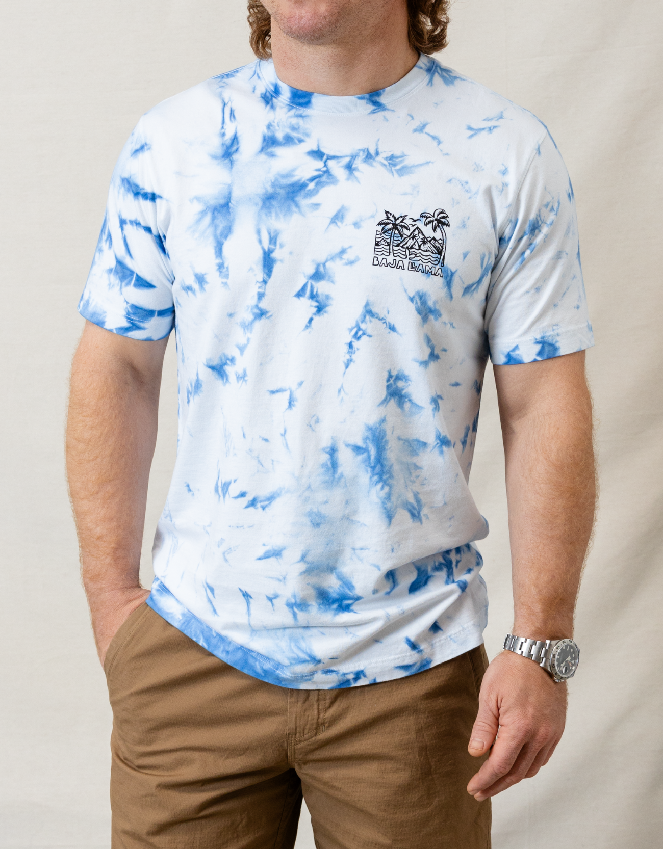 Wavy Dayz blue tie-dye graphic tee by Baja Llama. Features a vibrant, swirling tie-dye pattern with tropical ocean graphic on the front. Soft, comfortable fabric and relaxed fit, perfect for casual, adventurous style.