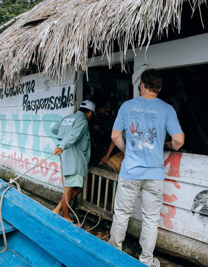 Back view of a man wearing the Baja Llama White Lobster acid wash Primo graphic tee, featuring detailed lobster illustration.