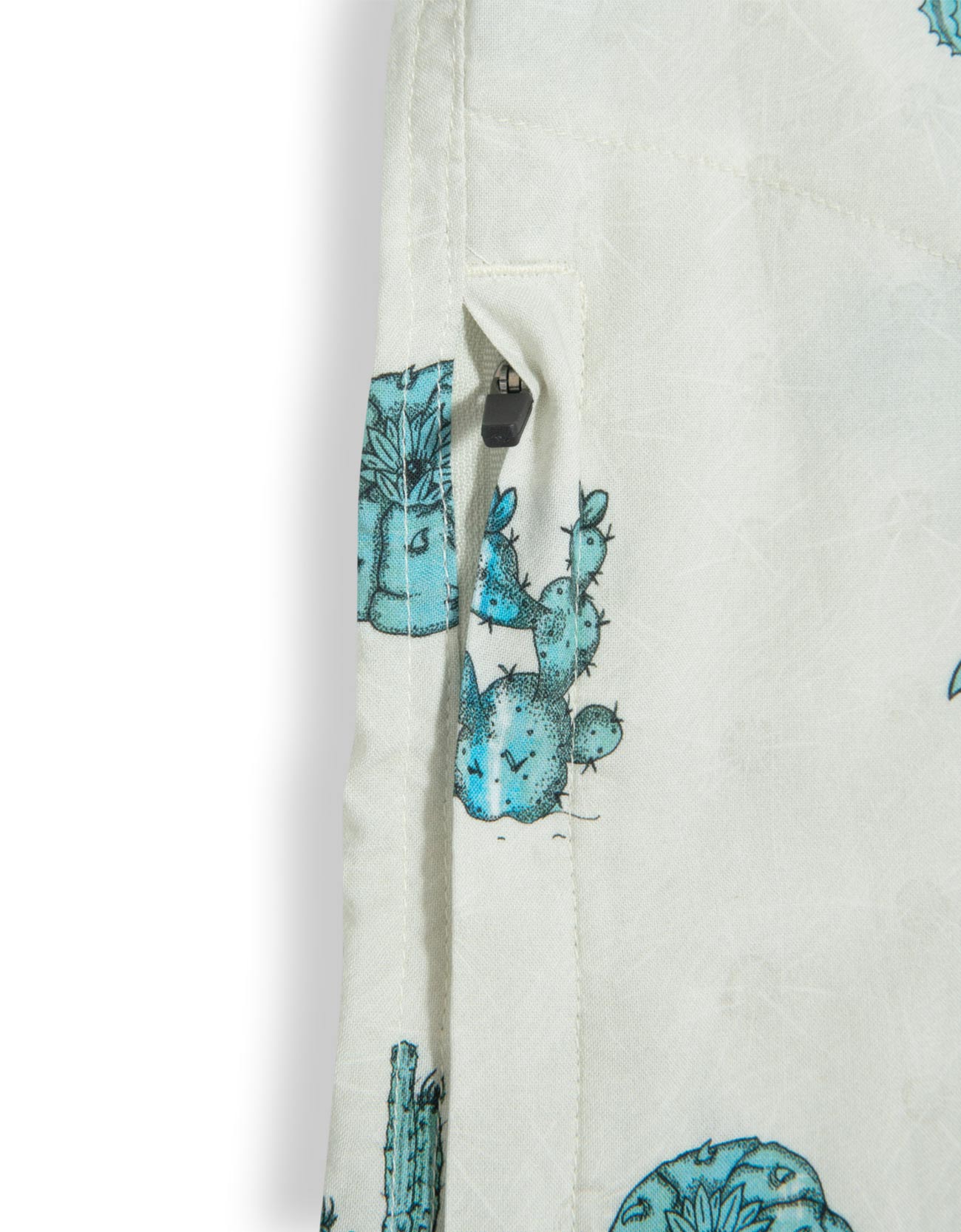 Tan button up shirt with various cactus print in turquoise