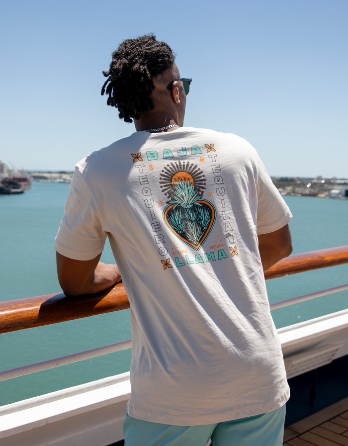 Back lifestyle view of cream Agave El Sativo Primo tee on boat overlooking turquoise water