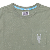 Close-up of the collar and chest area of the Baja Llama Greatful Dyed Rock On Cypress Green Heavy Tee, showing the crew neck, a blue checkered inner neck tape, and a chest pocket with white embroidered rock-on sign cactus