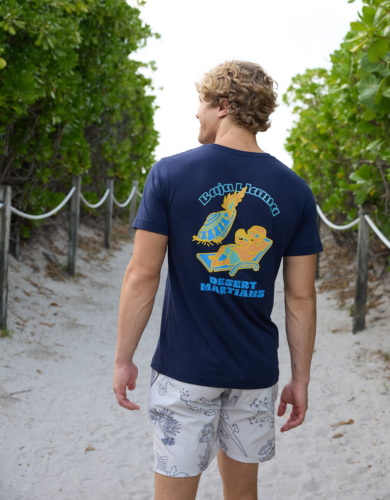 Back view of a man wearing the Desert Martians Primo Graphic Tee by Baja Llama showcasing the back graphic
