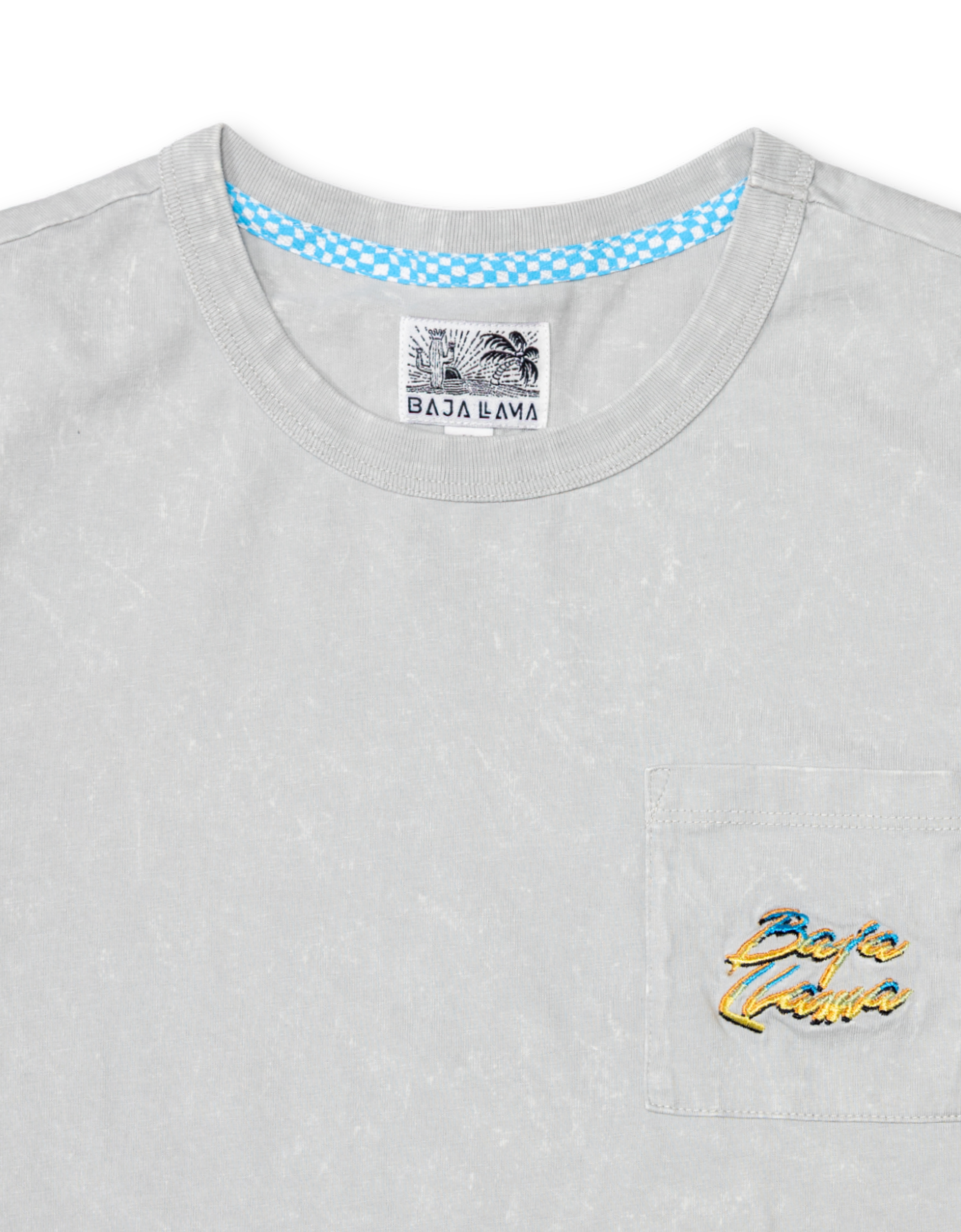 Close-up of the collar and upper chest area of the Baja Llama Greatful Dyed Shoreline Smoke Heavy Tee, showing the crew neck, blue checkered inner neck tape, and a chest pocket with a yellow and blue embroidered cursive brand logo