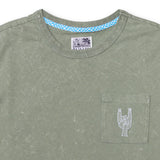 Close-up of the collar and chest area of the Baja Llama Greatful Dyed Rock On Cypress Green Heavy Tee, showing the crew neck, a blue checkered inner neck tape, and a chest pocket with white embroidered rock-on sign cactus