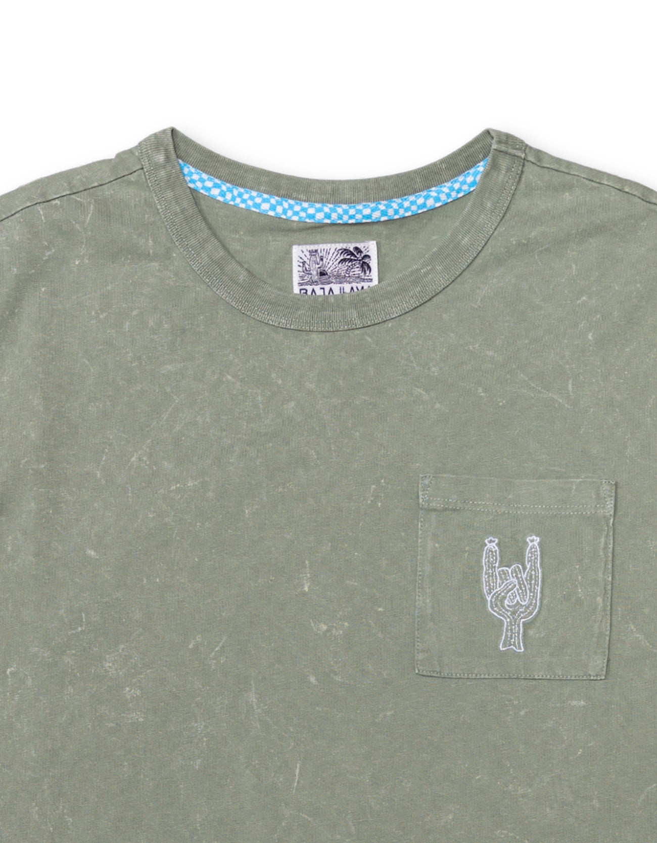 Close-up of the collar and chest area of the Baja Llama Greatful Dyed Rock On Cypress Green Heavy Tee, showing the crew neck, a blue checkered inner neck tape, and a chest pocket with white embroidered rock-on sign cactus
