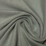 A close-up view of the Baja Llama Greatful Dyed Rock On Cypress Green Heavy Tee fabric, tightly swirled to display the heavy cotton texture and vintage-wash olive green color.