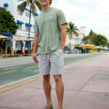 Man walking down a sunny street wearing the Baja Llama Greatful Dyed - Rock On Cypress Green Heavy Tee