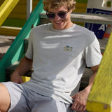 Man sitting on wooden steps wearing the Baja Llama Greatful Dyed - Shoreline Smoke Heavy Tee