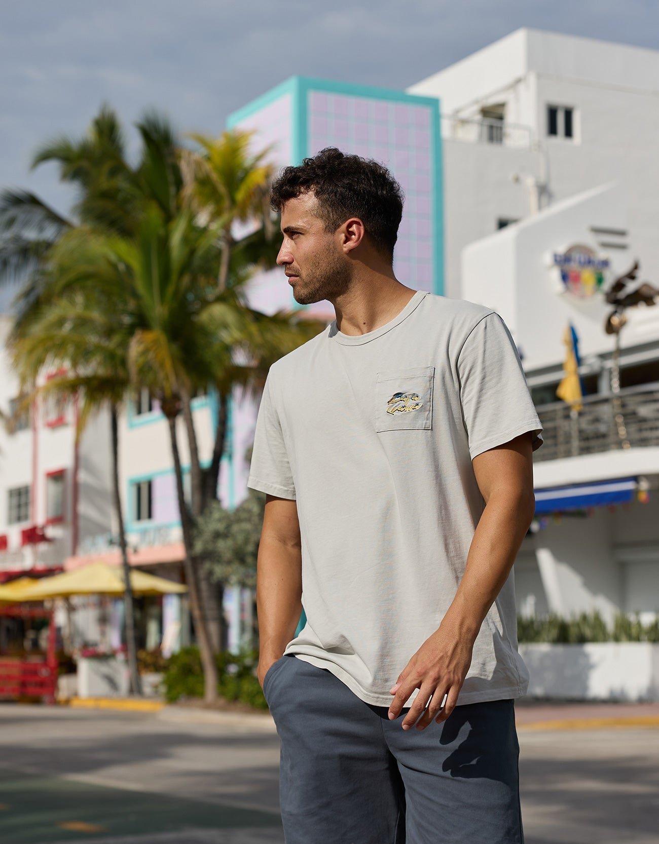 Man wearing the Greatful Dyed Shoreline Smoke Heavy Tee by Baja Llama with front pocket detail, outdoor lifestyle shot