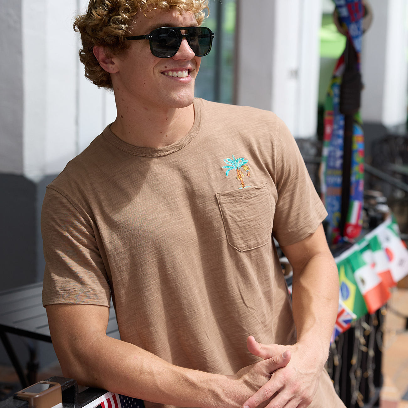 Man wearing Baja Llama La Republica Embroidered Pima Slub Pocket Tee outdoor lifestyle portrait with sunglasses
