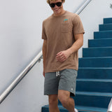 Smiling man walking near blue outdoor steps wearing Baja Llama La Republica Embroidered Pima Slub Pocket Tee