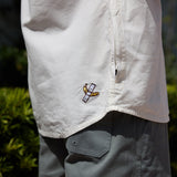 Close-up of white 7-Seas button-up shirt featuring custom hem embroidery and side pocket detail by Baja Llama