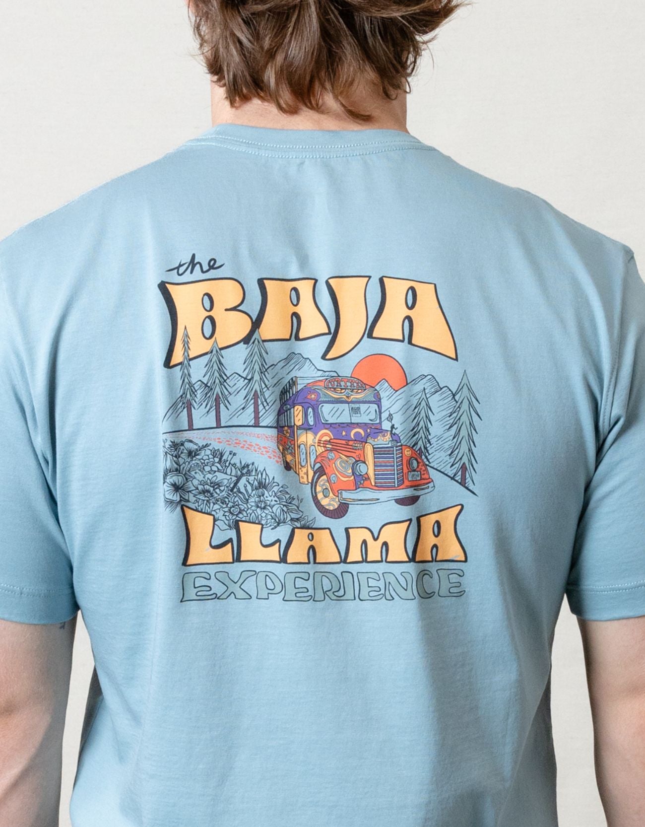 Bus Experience graphic tee by Baja Llama. Light teal tee with a retro bus design. Soft fabric and relaxed fit, perfect for laid-back, adventurous style.