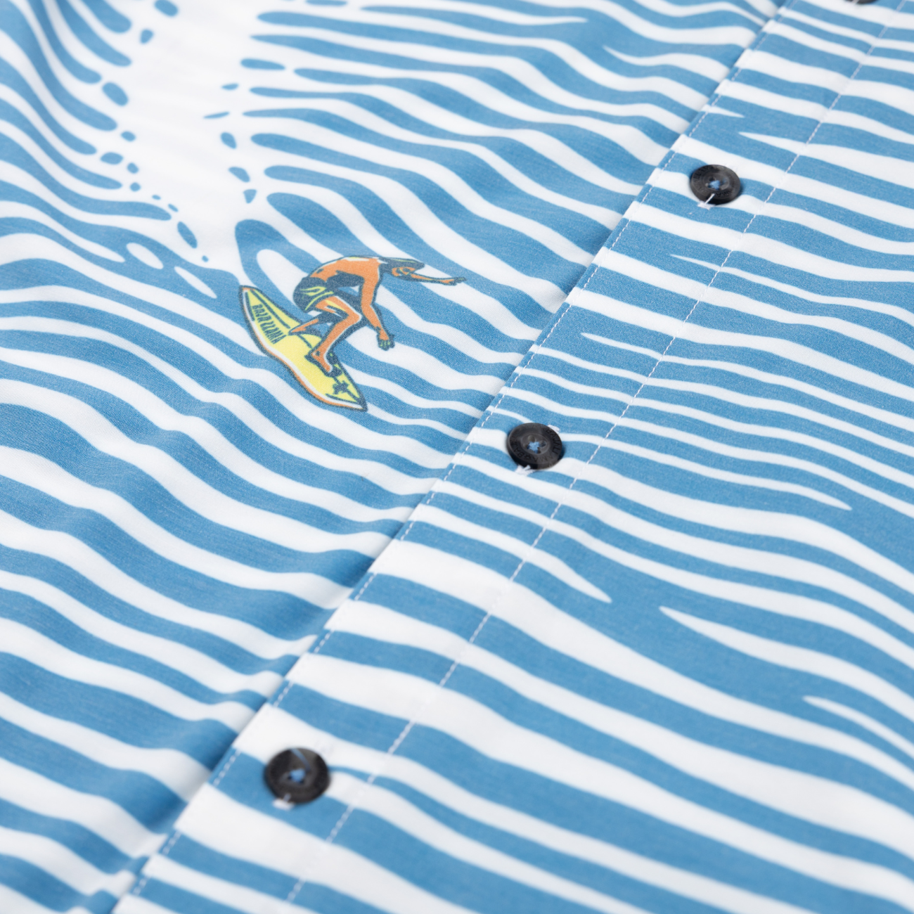 Baja Llama Ocean-wave stripe shirt with surfer graphic. Bold, breezy, and made for coastal adventure.