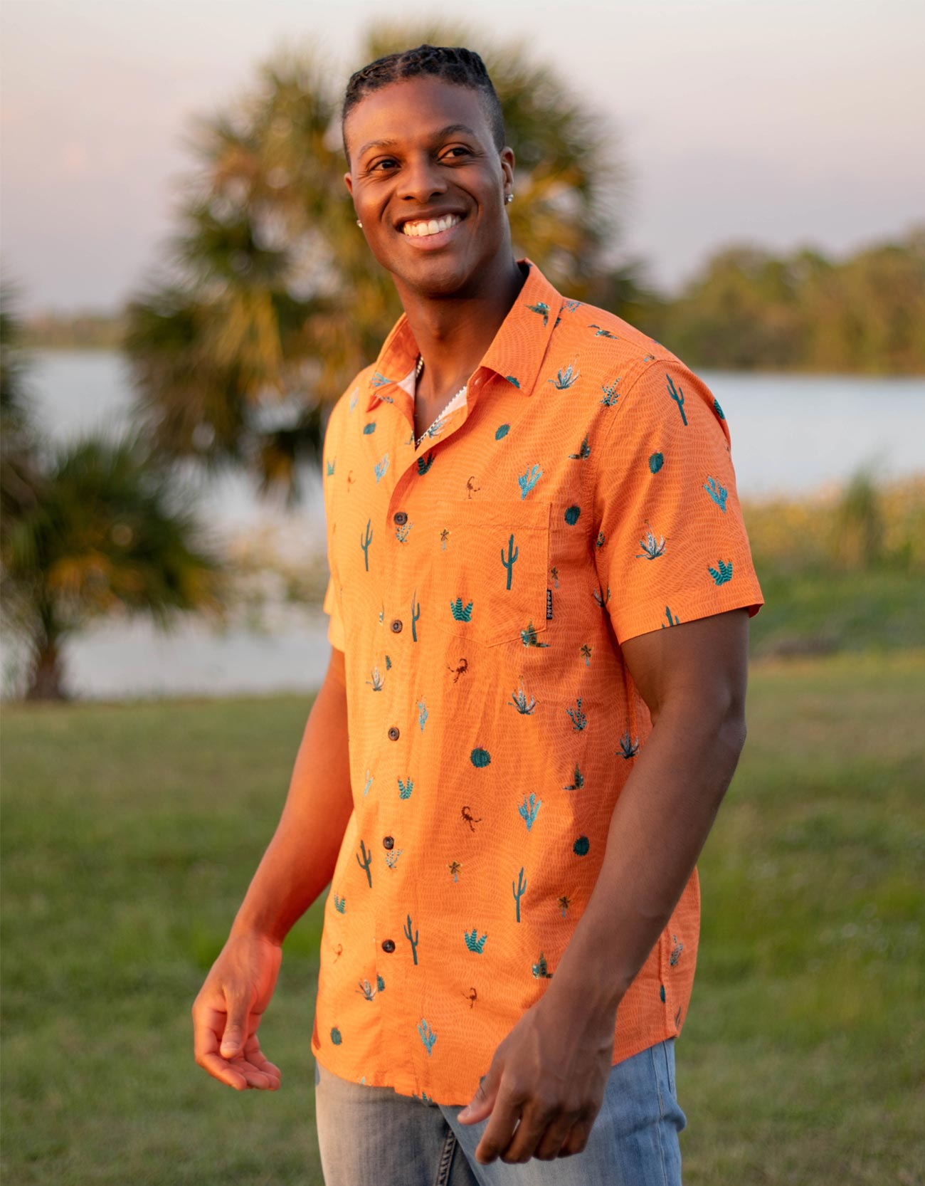 Button up shirt with hand painted watercolor cactus design on orange background.