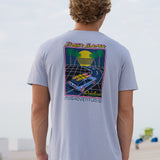 Back view of a model wearing the Radical Misadventurist purple acid wash graphic tee featuring a retro car and palm tree back print