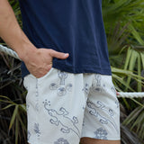 Baja Llama Relaxplorations Desert Martians Athleisure Shorts styled with a navy blue t-shirt outdoors near tropical foliage.