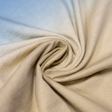 A close-up view of the Baja Llama Rock On Cactus Embroidered Primo S.E. Heavy Tee fabric, tightly swirled to showcase the heavy cotton texture and the smooth gradient transition from ocean blue to sandy tan