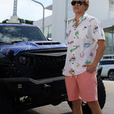 Baja Llama The BBQ Shirt 7-Seas Relaxed Fit Button Up in white worn by a model next to a custom truck.