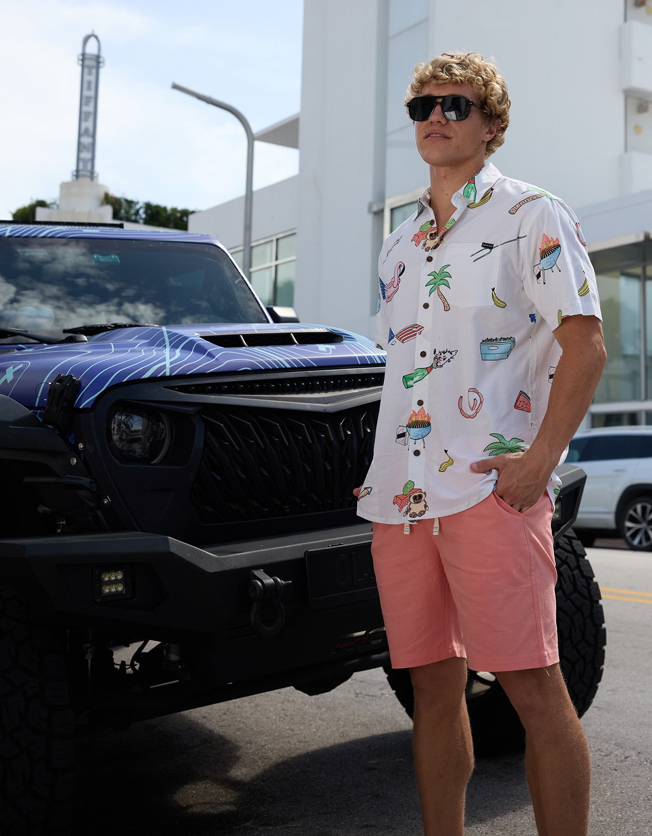 Baja Llama The BBQ Shirt 7-Seas Relaxed Fit Button Up in white worn by a model next to a custom truck.