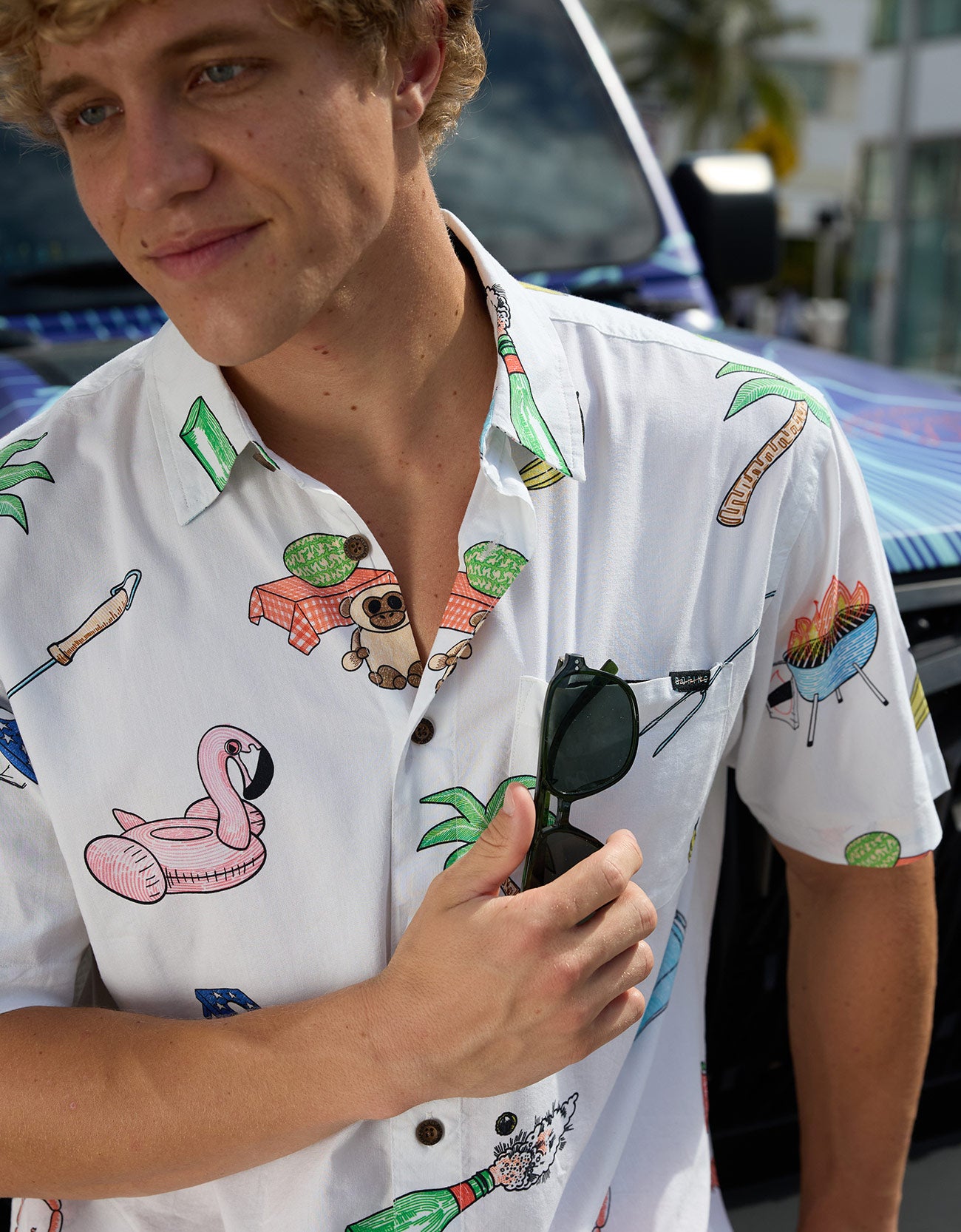 Close-up of the Baja Llama The BBQ Shirt white relaxed-fit button-up showing the playful summer cookout print, chest pocket, and sunglasses