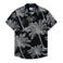 Front view of THE CANOPIES ARE ALIVE - NIGHTHAWK™ RELAXED FIT BUTTON UP from Baja Llama, a black short-sleeve shirt featuring an intricate white hand-drawn print of palm trees and monkeys.