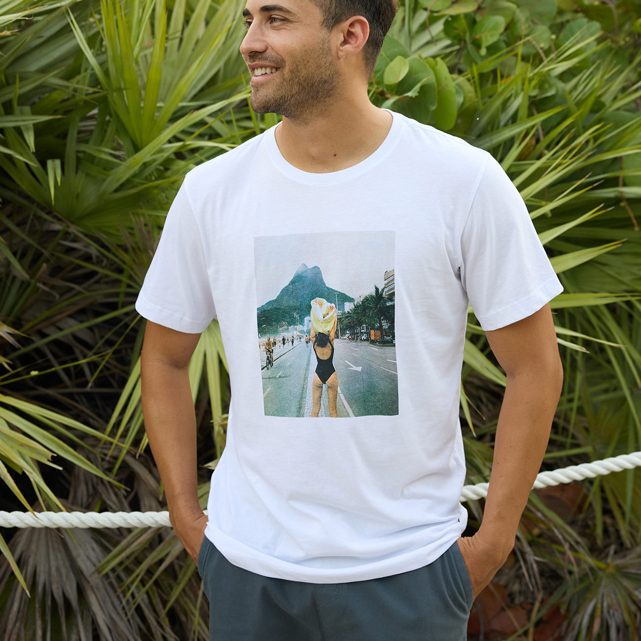 Baja Llama The Girl In Ipanema Primo Graphic Tee white short sleeve t-shirt worn by a smiling model outdoors.